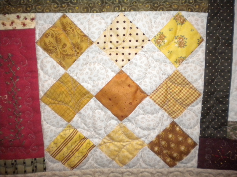 White Quilt with Yellow-Hued Pattern Diamond Blocks and Colorful Border