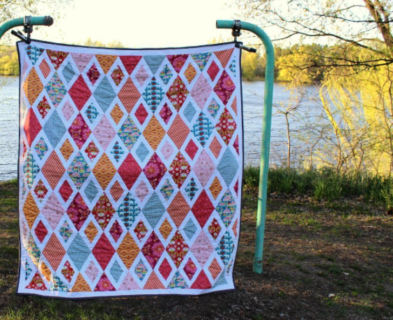 Colorful Diamond-Patterned Blanket Hanging Against Natural Background