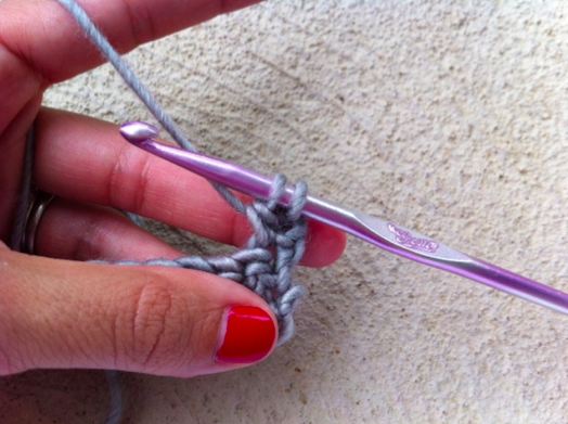 Woman's Hands Pulling Yarn Through Loop with Crochet Hook