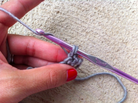 Woman's Hands Looping Yarn Around Crochet Hook