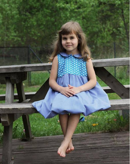 Little Girl Wearing Blue Dress, Sitting on Picnic Bench 