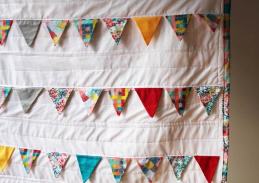Hanging White Quilt with Patterned Triangle Details
