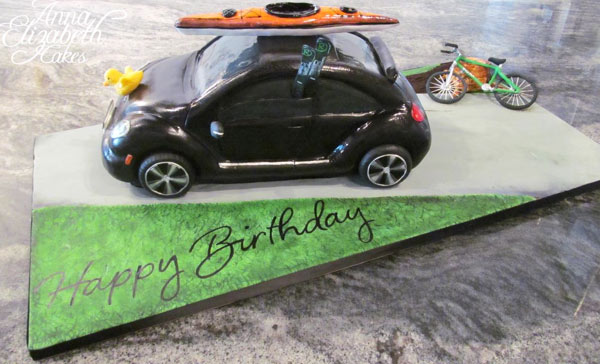 Cake in Shape of Little black Car with Surfboard on Top