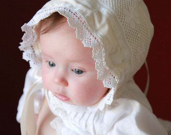 Baby Girl Wearing White Dress and Bonnet