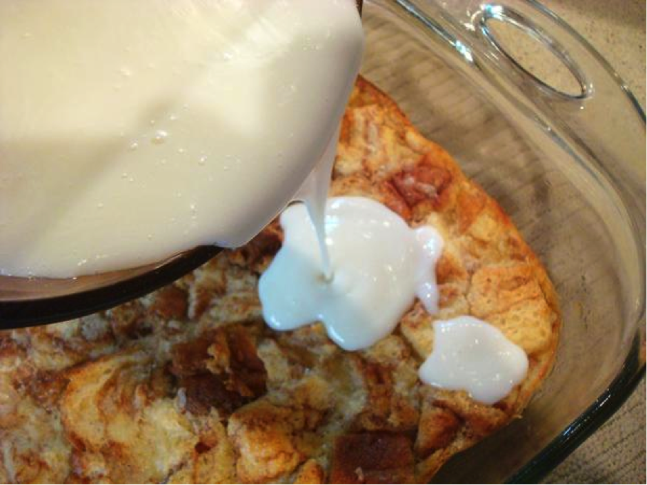 Icing Being Poured from Bowl onto Bread Pudding