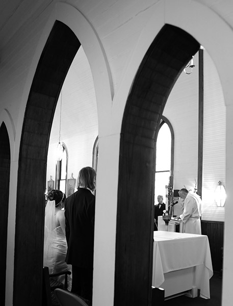 Black and White Artistic Photo of Wedding Scene Through Archways