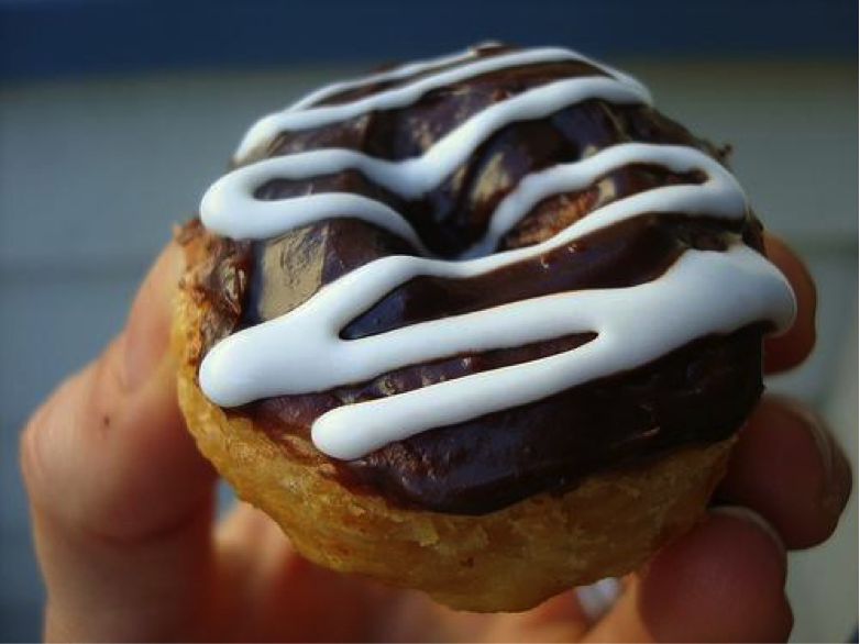 Hand Holding Doughnut Pie with Chocolate Icing