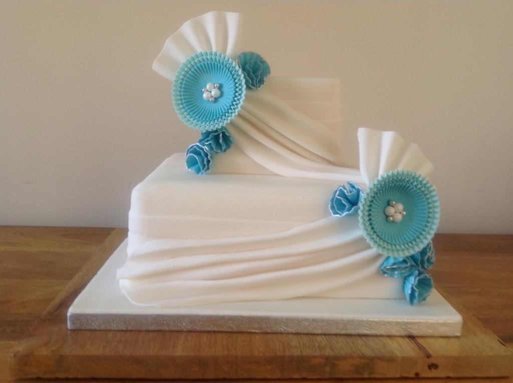 White Wedding Cake with Draping and Blue Flowers