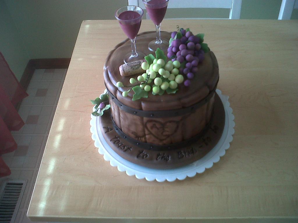 Cake in Shape of Wine Barrel Topped with Two Wine Glasses and Grapes