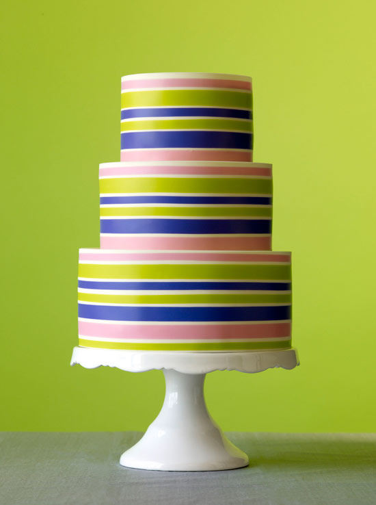 Colorful Striped 3-Tier Wedding Cake Against Bright Green Background