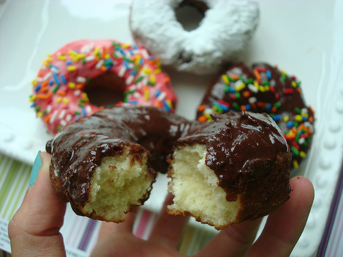 Hand Holding Donut with Bite Out of It