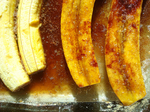 Plátanos en la bandeja del horno en proceso de ser volteados