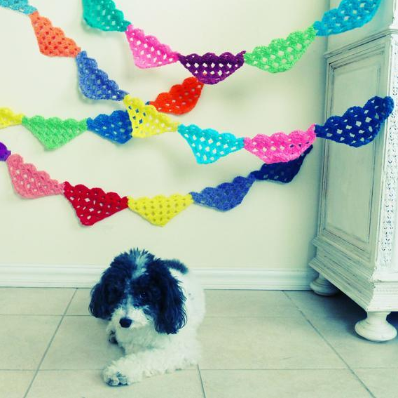 Cute Dog Sitting Below Strands of Quilted Garlands