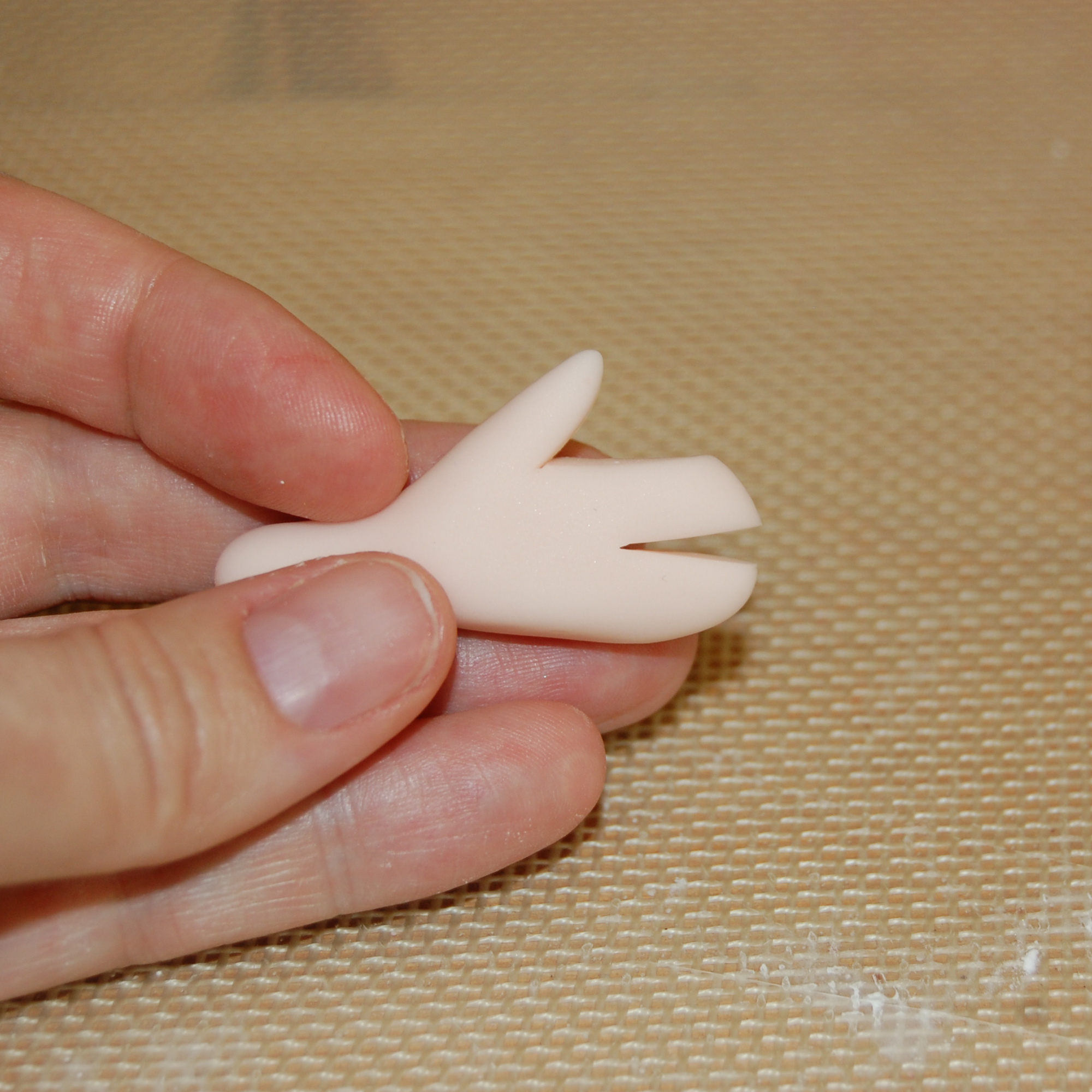Close Up on Hand Holding Same Piece of Fondant, Sliced in Middle