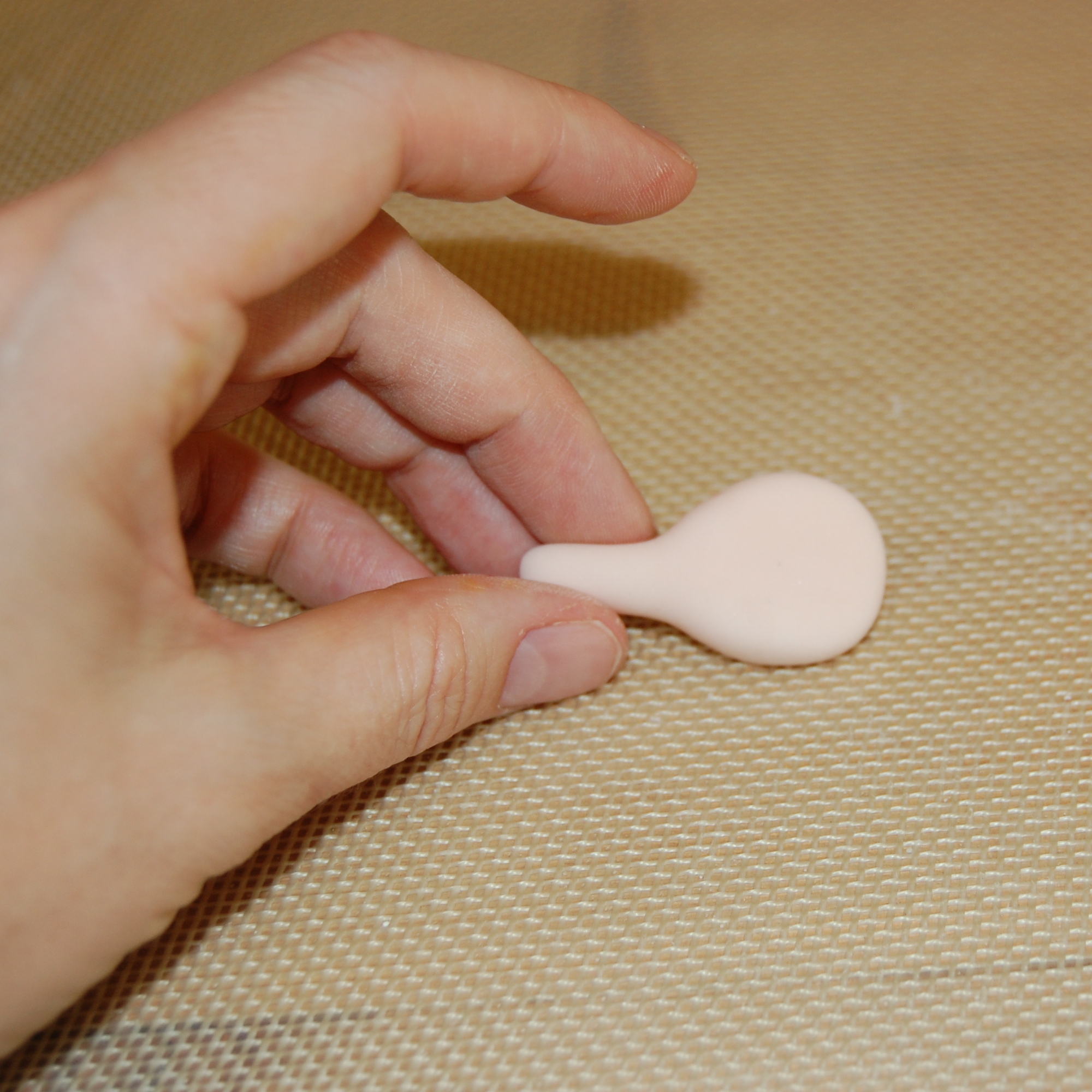 Hand Holding Tip of Fondant Between Fingers