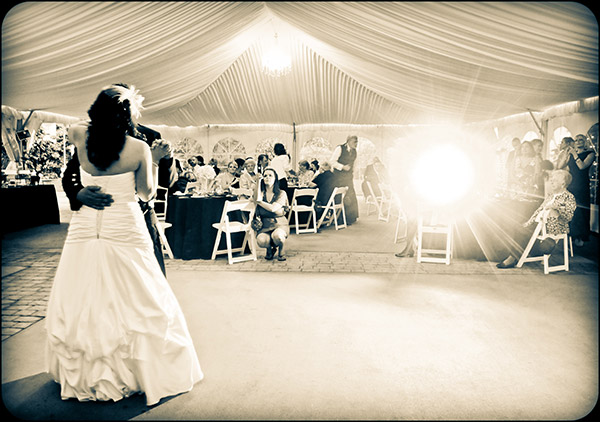 Sepia Image of Bride and Groom on Dance Floor, Bright Light in Background
