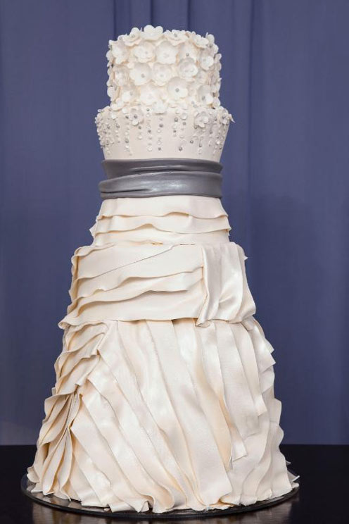 Tiered Wedding Cake with Ruffles and Flowers, Resembling Very Clearly a Wedding Dress