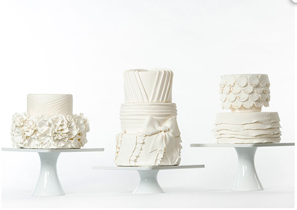 Three White Bridal Cakes, Each Uniquely Textured, on White Stands