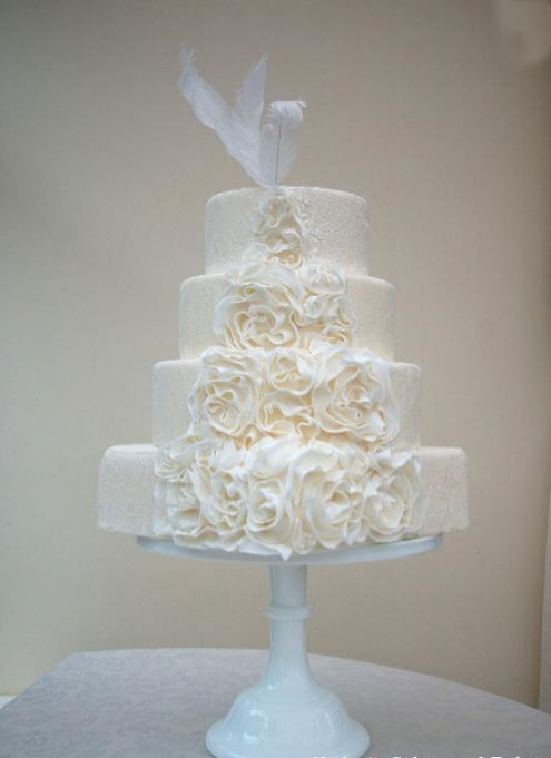 Cream-Hued Wedding Cake with Ruffled Roses and Feathers