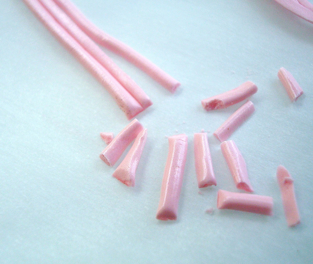 Pink Icing Strands Being Cut into Sprinkles