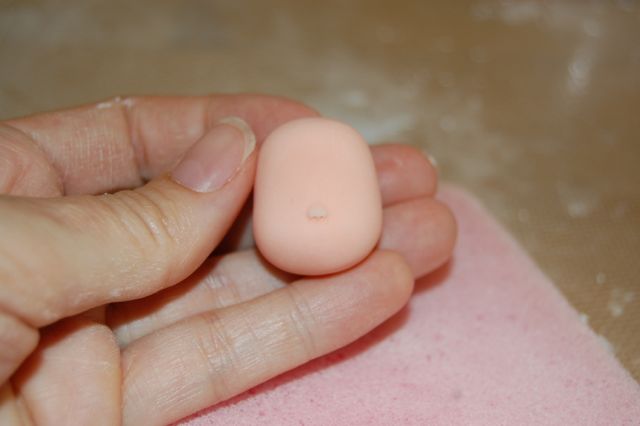 Hand Holding Piece of Shaped Fondant with Little Nose