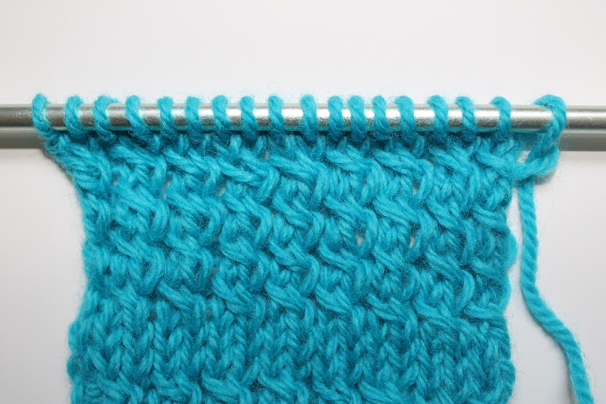 Close Up of Knit Blue Yarn on Knitting Needles