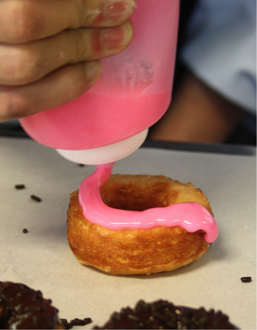 Cronut Being Iced with Pink Glaze