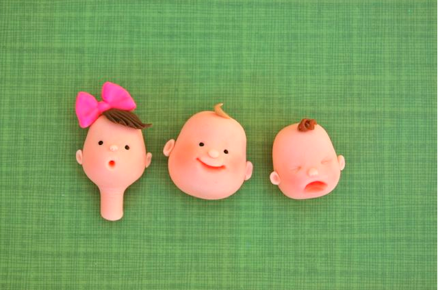 Three Finished Fondant Baby Faces on Mat