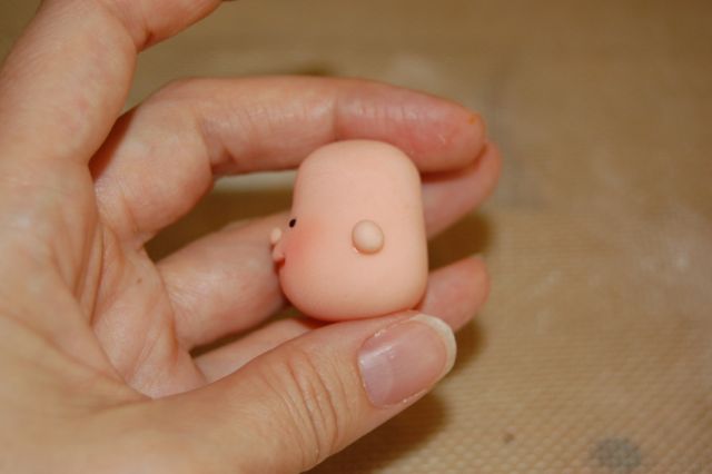 Hand Holding Fondant Head in Hand, View of Ear