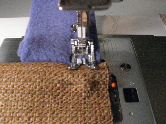 Close Up on Sewing Machine Foot with Two Pieces of Fabric Feeding In