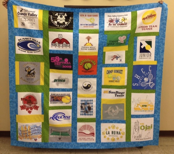 Woman Holding Up Quilt Featuring Multitudes of Logos 