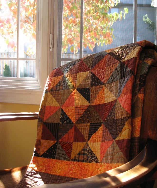 Fall Colored Quilt Folded in Chair, Fall Leaves Out Window