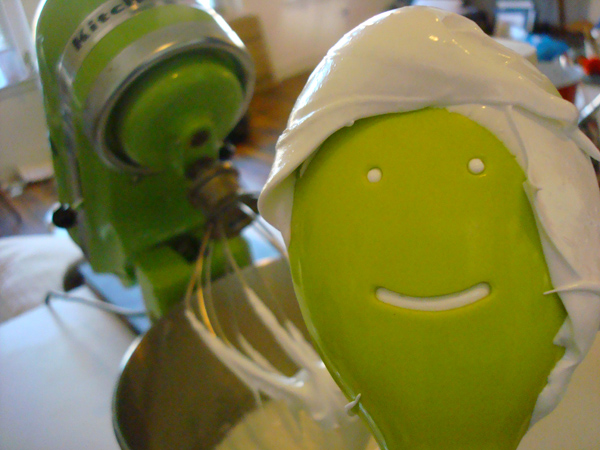 Spoon with Smiling Face and Frosting 'Hair', Mixer in Background
