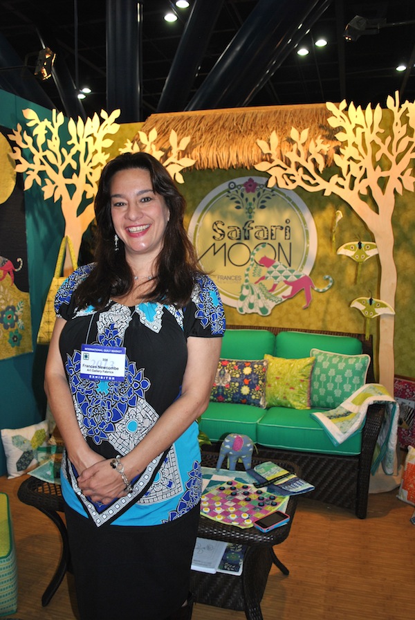 Woman Smiling in Front of Booth at International Quilt Market