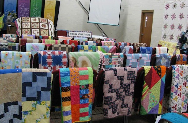 Dozens of Quilts Hanging on Railings