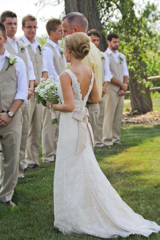 Bride in Wedding Dress Standing in Front of Groomsmen