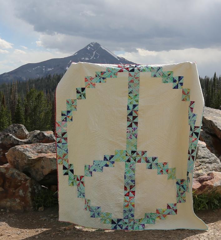 White Quilt Featuring Patterned Peace Sign 