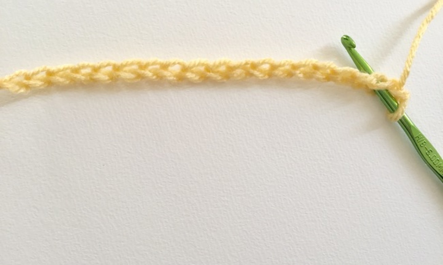 Cadena de hilo amarillo con gancho verde