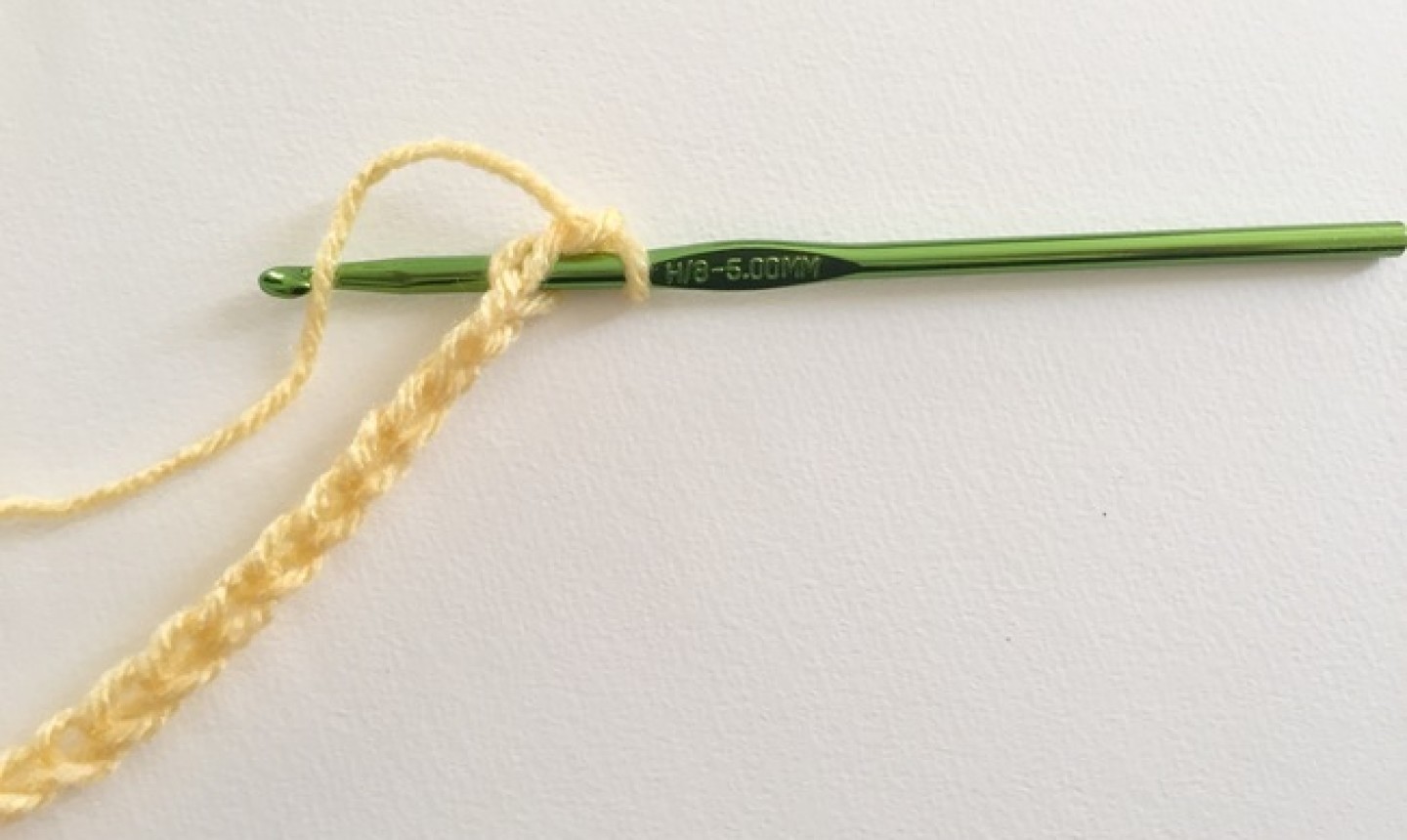 Cadena de hilo amarillo con gancho verde