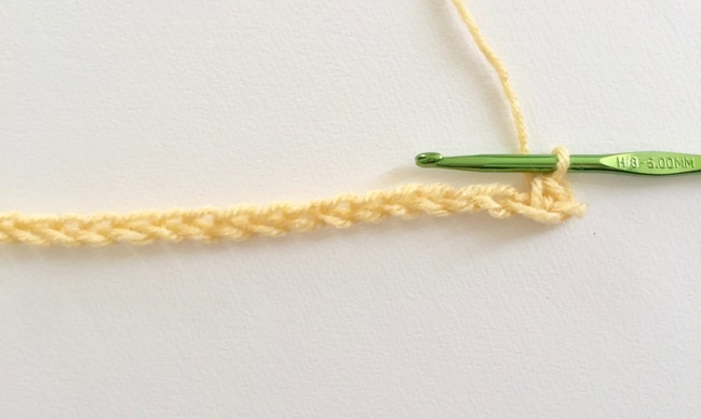 Cadena de hilo amarillo con gancho verde