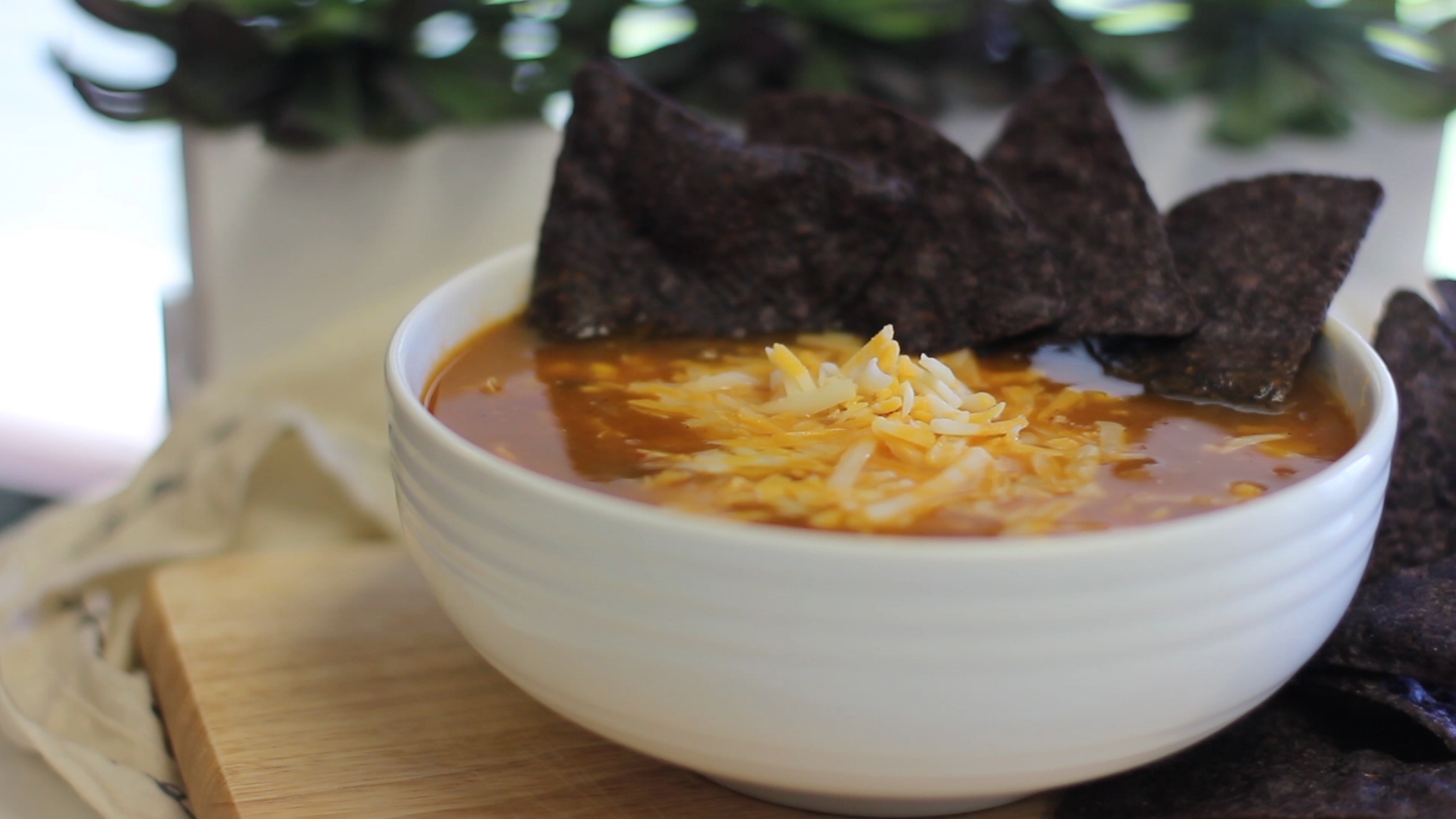 Southwest soup topped with cheese and blue corn tortilla chips