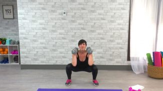 Woman doing a low squat with dumbbells