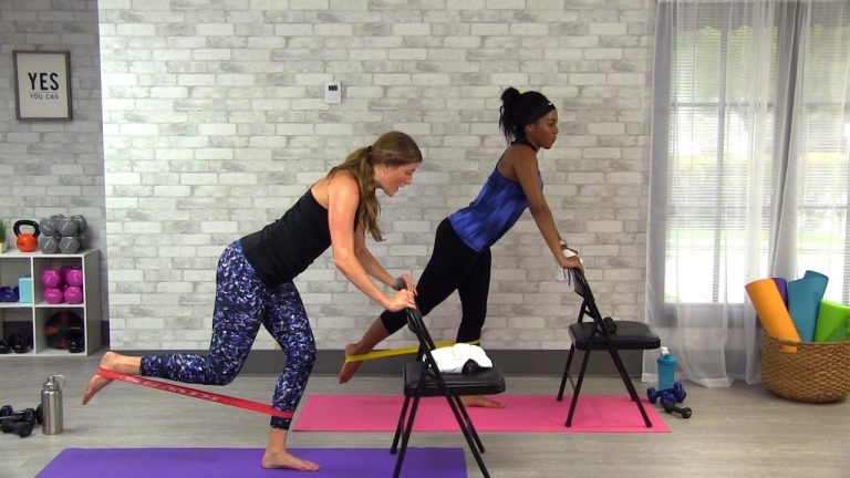 Two women using mini bands and chairs to workout