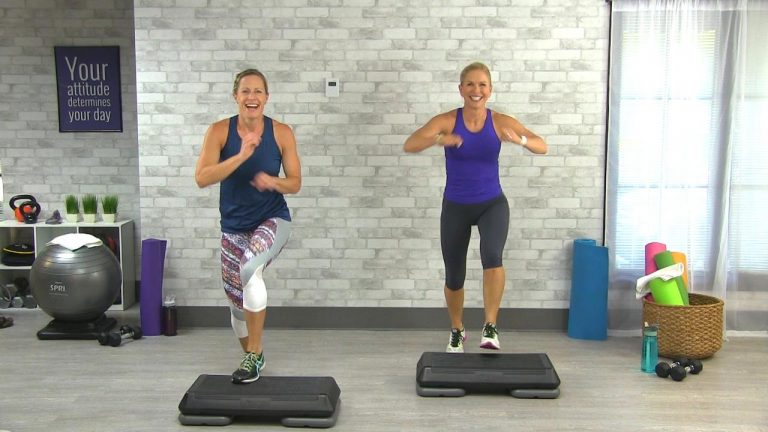 Two women doing a cardio workout with a step
