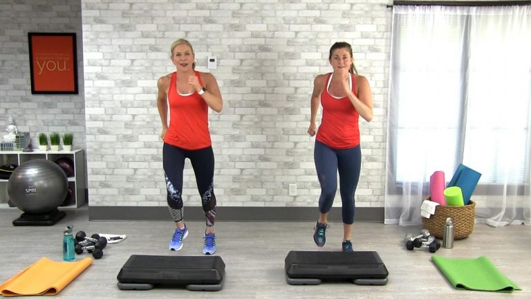 Two women doing a step workout clas