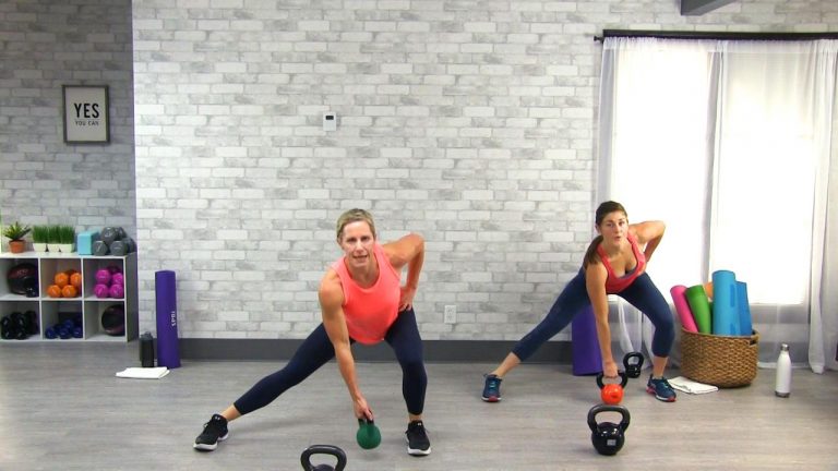Two women doing lateral lunges with kettlebells