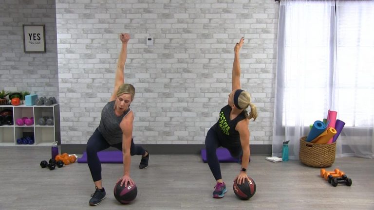 Two women working out with medicine balls