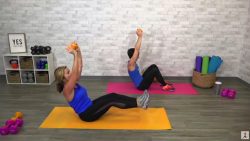 Two women doing a core workout with a dumbbell