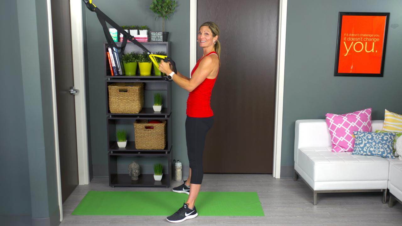 Woman using a TRX in her house
