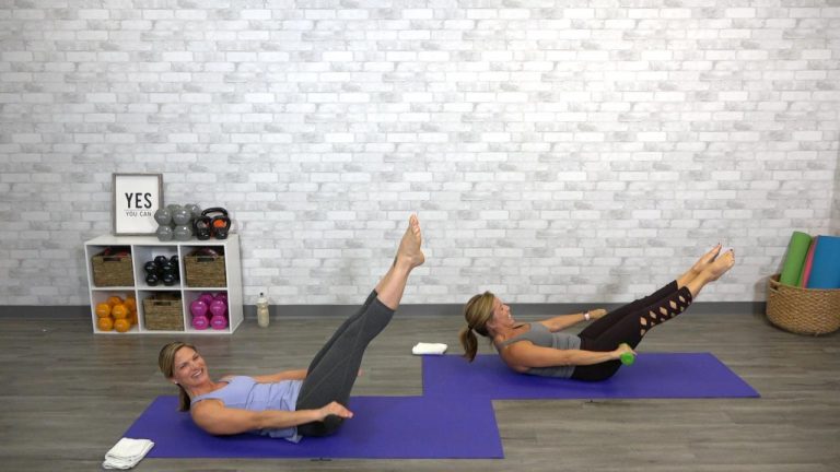 Two women doing pilates with weights